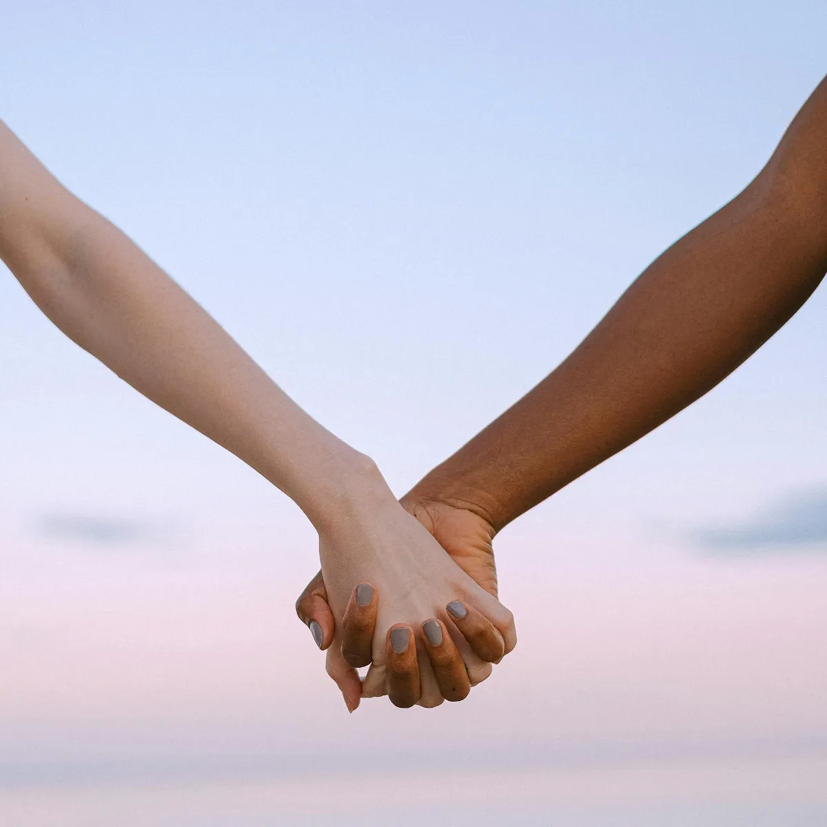 Hands holding with the sunset in the background